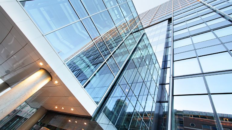 Verkauf problembehafteter Immobilien-Portfolios: Bürogebäude mit Glasfront.