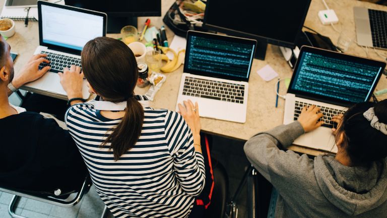 KI-Entwicklung in Unternehmen: Ein Team von Entwicklern programmiert KI-Software.