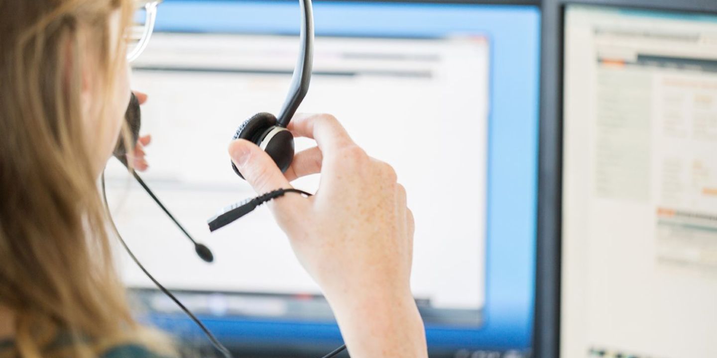 Künstliche Intelligenz im Callcenter: Eine Callcenter-Mitarbeiterin setzt sich ihr Headset auf.