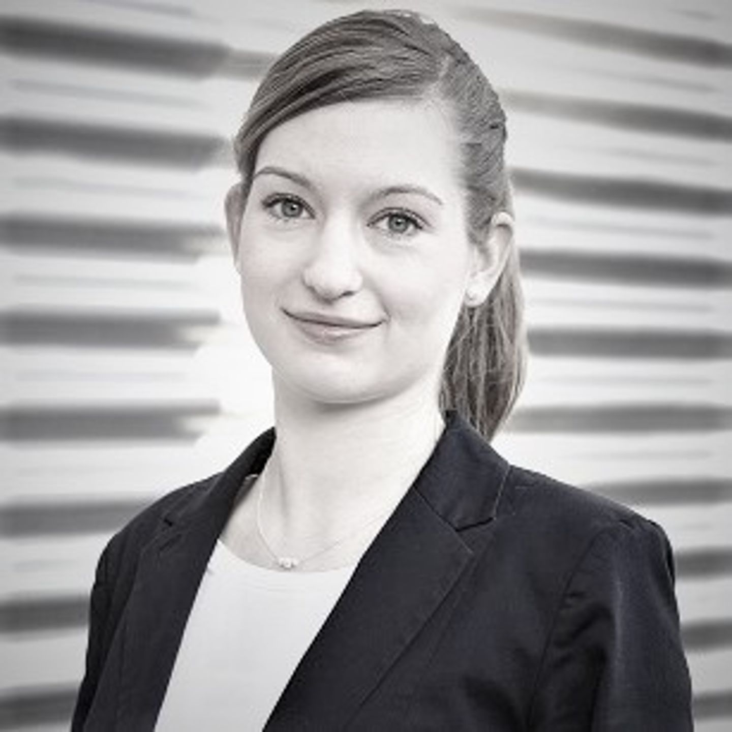 Portrait der weiblichen Expertin Anja Koerber, Head of Artificial Intelligence & Automation in der Otto Group, mit einem Zopf und Blazer. 