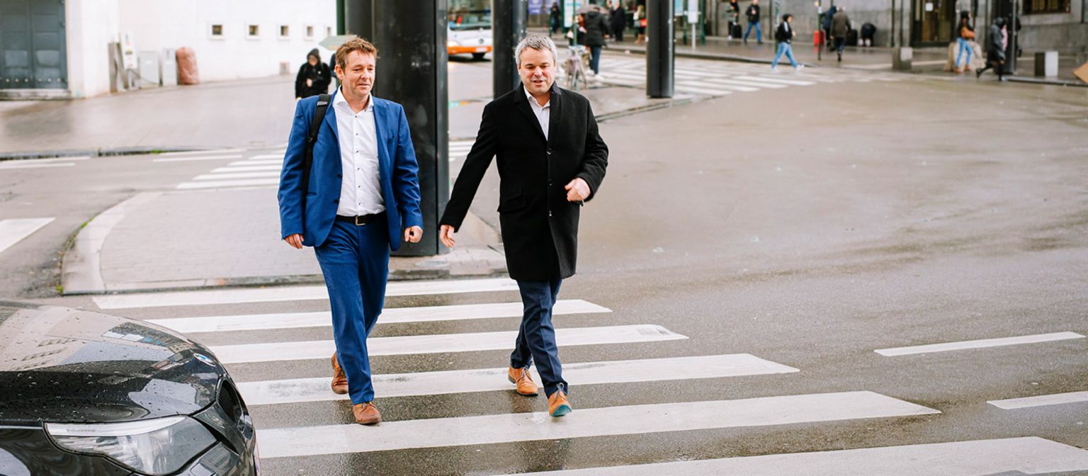 Roel Dumont und Ivan Demuynck überqueren eine Straße.