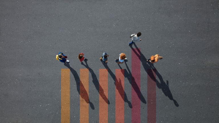 Einkommensabhängige Kredite: Student*innen laufen begleitet von Säulen über einen Platz.