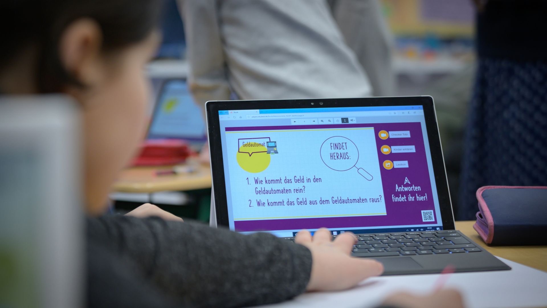 Finanzbildung für Kinder: Kind sitzt am Laptop und lernt etwas über Finanzen.
