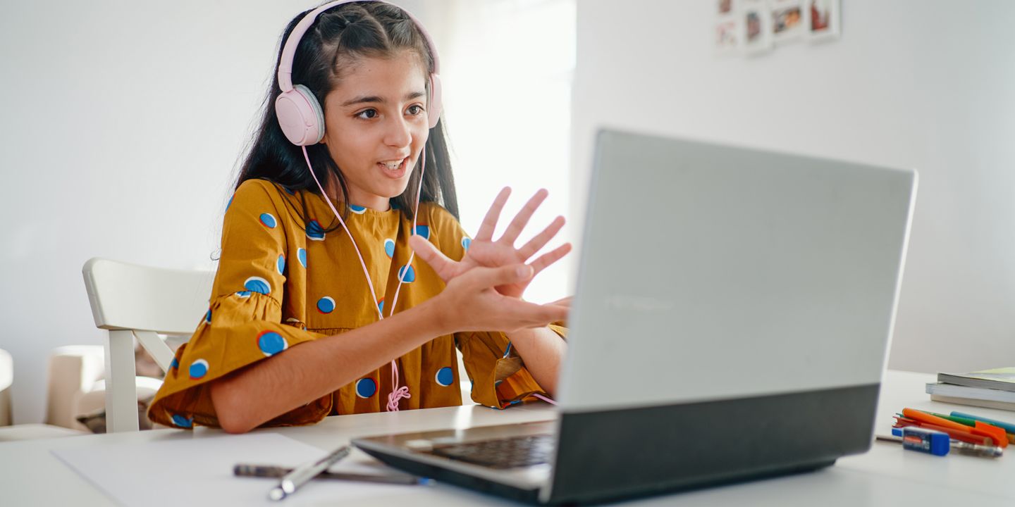 Finanzbildung ist Verantwortung: Mädchen sitzt am Laptop und nimmt an Online-Unterricht teil. 