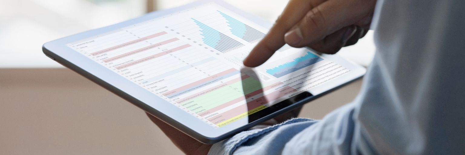 Close up of a man going through a data analysis on a tablet