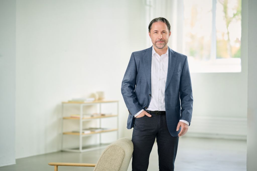 Portrait of Marwin Ramcke, Chairman of the EOS Group's Board of Directors in a bright room wearing a dark blazer 