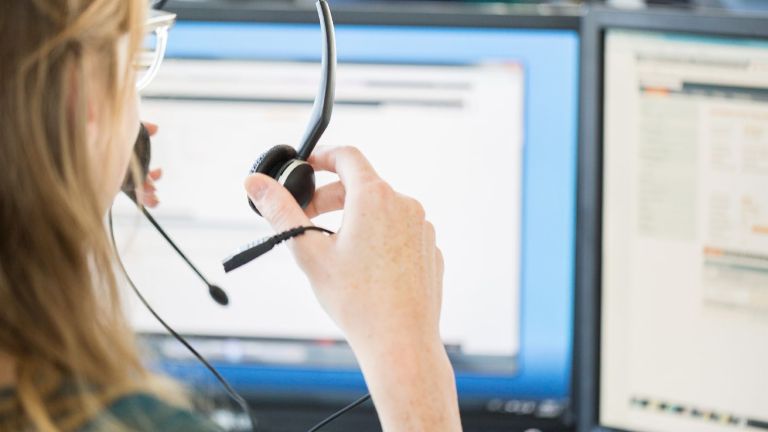 Künstliche Intelligenz im Callcenter: Eine Callcenter-Mitarbeiterin setzt sich ihr Headset auf.