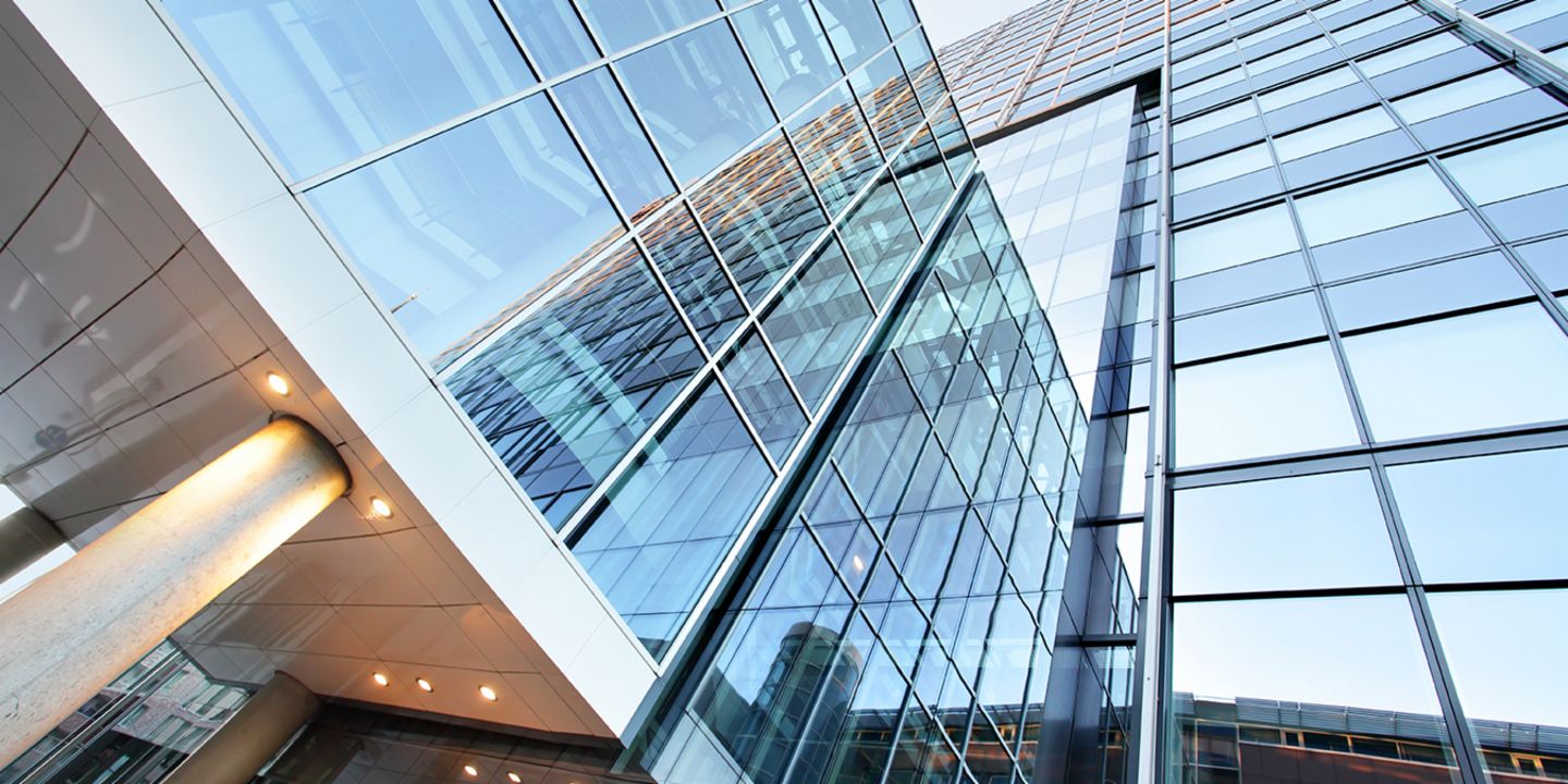 Verkauf problembehafteter Immobilien-Portfolios: Bürogebäude mit Glasfront.